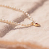 Freshwater pearl necklace with gemstone drop charm laid flat, AllureNL